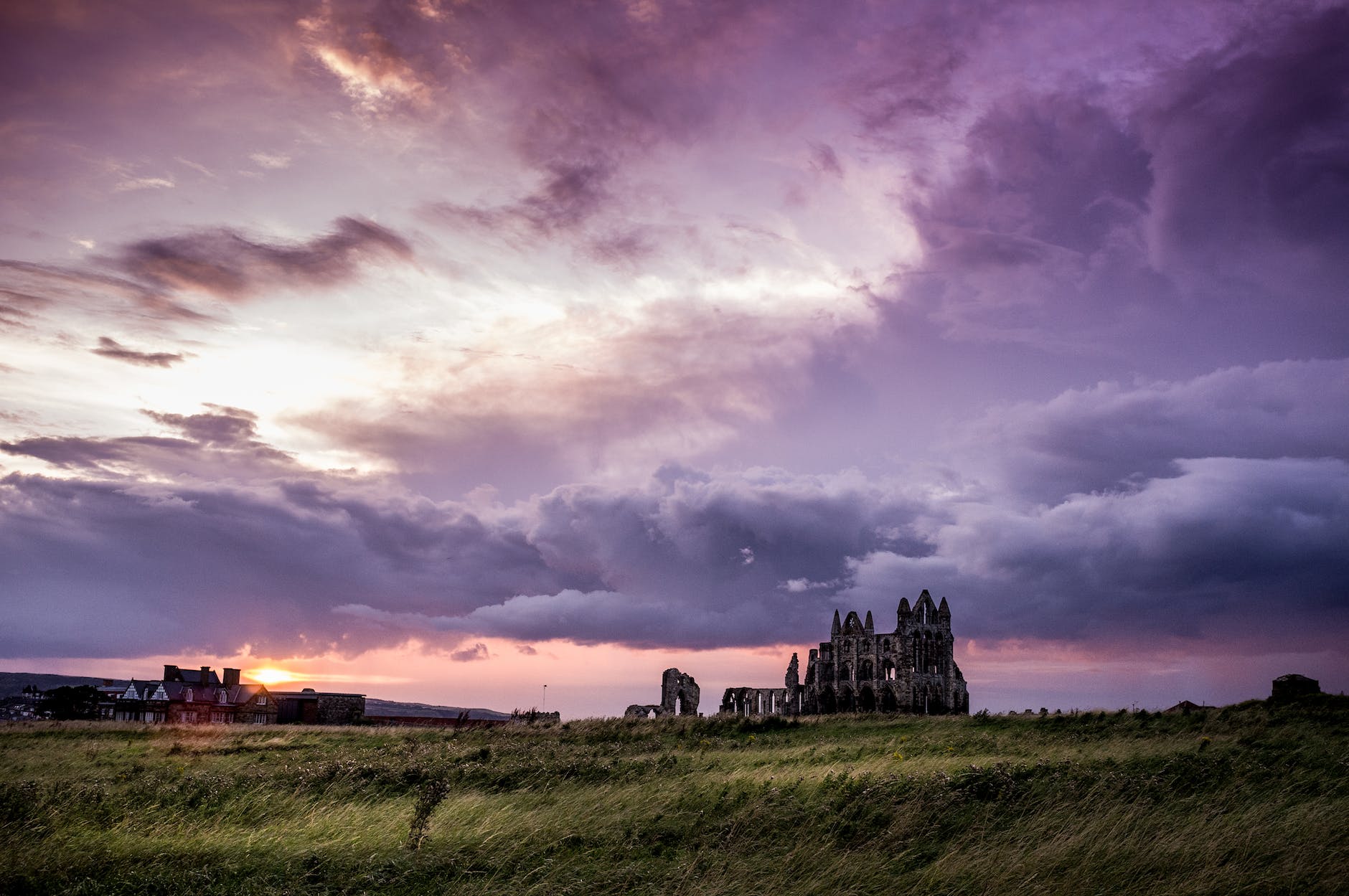 green field and white and black concrete structure during sunset